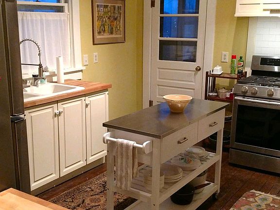 Kitchen has refrigerator, range, microwave, butcher block counters, and center island. Access porch from kitchen