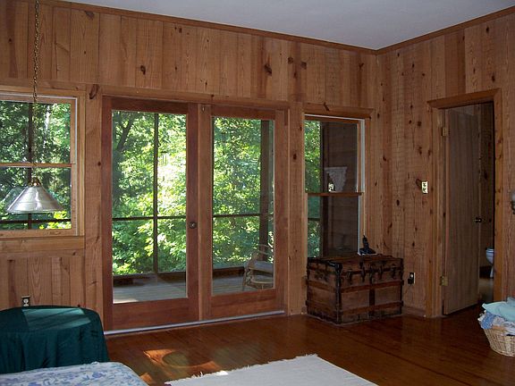The rustic master bedroom has access to a private screen porch