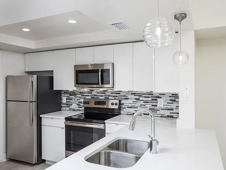 Modern kitchen with stainless steel appliances, granite countertops and designer cabinets