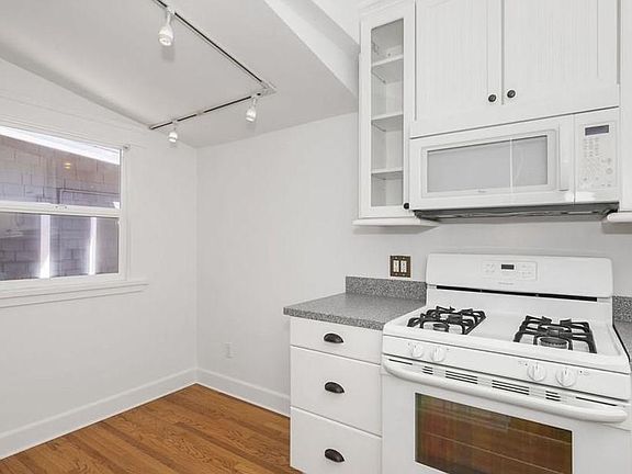 Eat-in kitchen with gas stove and refrigerator.