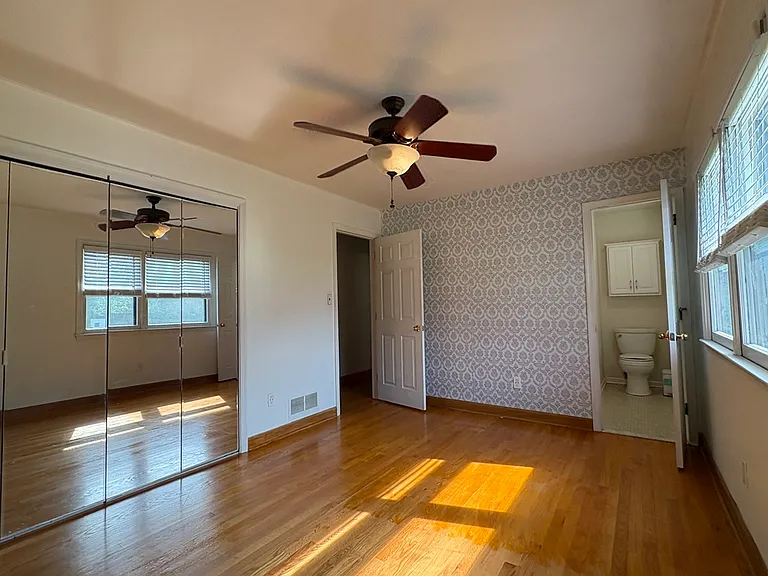 View of Primary Bedroom w/ Clg Fan & 1/2 Bath