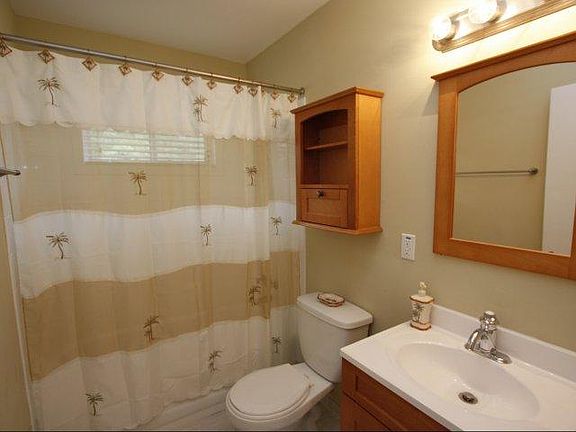 Nice tidy bathroom with fullsize tub. White tile floors.