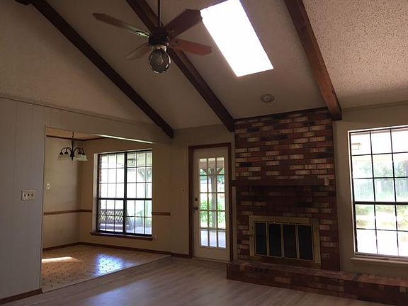 cathedral ceiling with wood burning fireplace and sky light