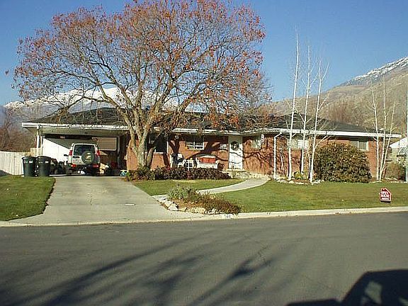 Photo of home in winter showing mature trees and Mt Timp in backround