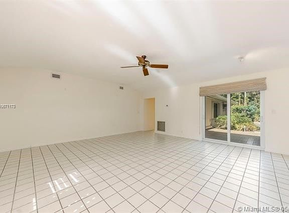 Notice the vaulted ceiling, the new Dan's Fan and the all tile floors that run thru the whole house. The Impact Sliding glass doors open to nice tiled patio and the very private backyard accented by palms and the large "Ponytail" Palm just like at Fairchi