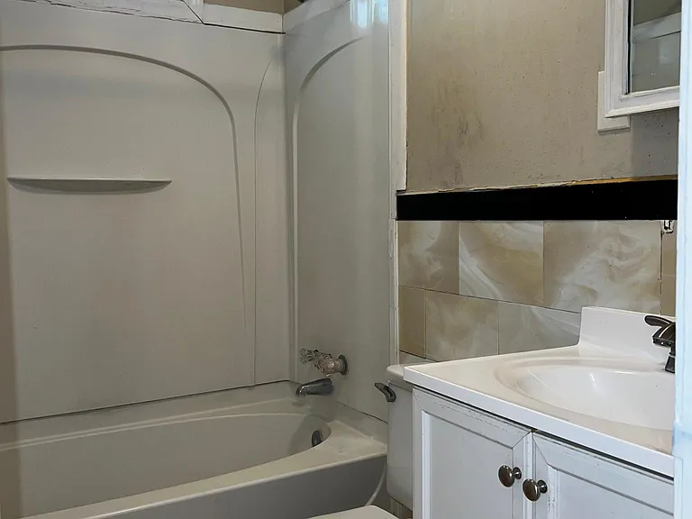 Full bath with lifetime surround shower stall and tub, new toilet and vanity. There is a small Ventilation window in the bath.