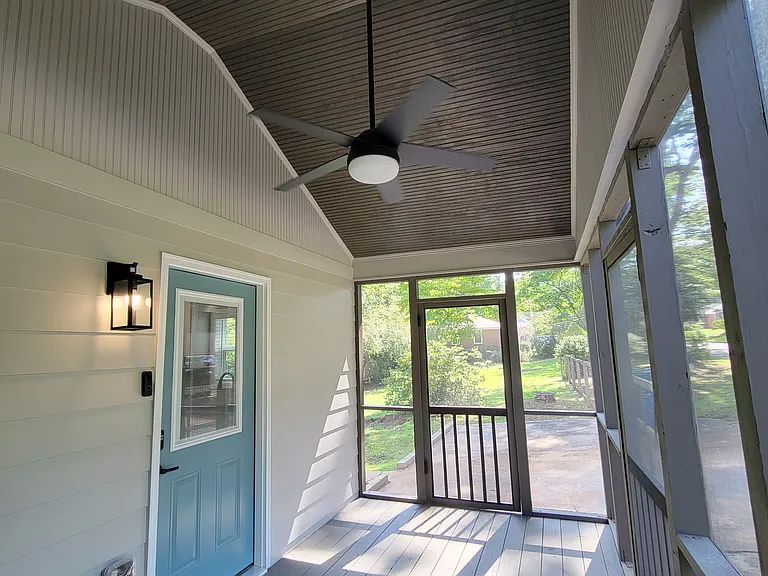 Soaring ceilings and ceiling fan at screened-in porch.