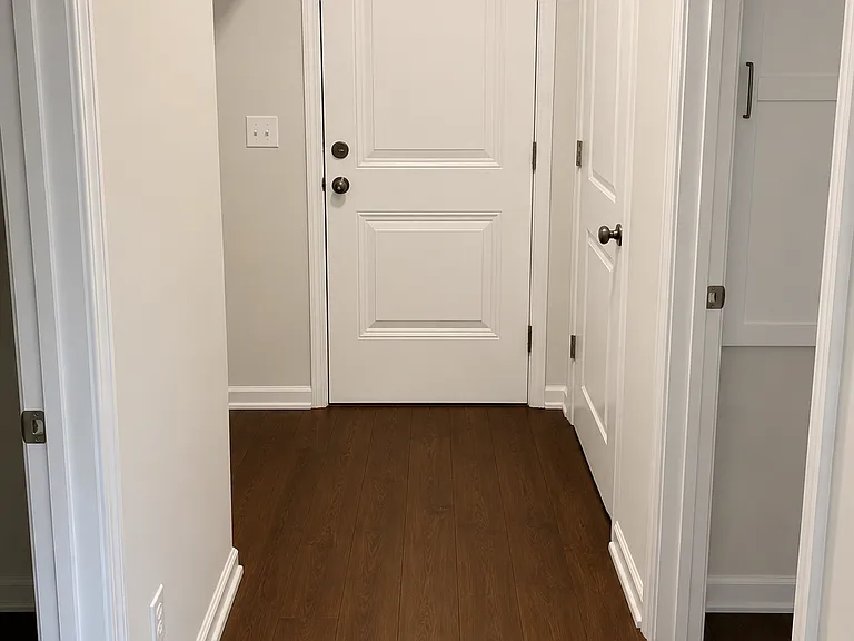 Hallway to garage, office on right, bathroom on left, storage under stairs