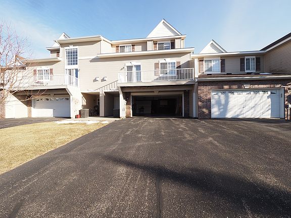 Front of unit with garage open, spacious deck.