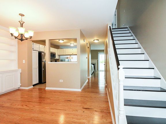 Dramatic wooden staircase adjacent to large dining room.