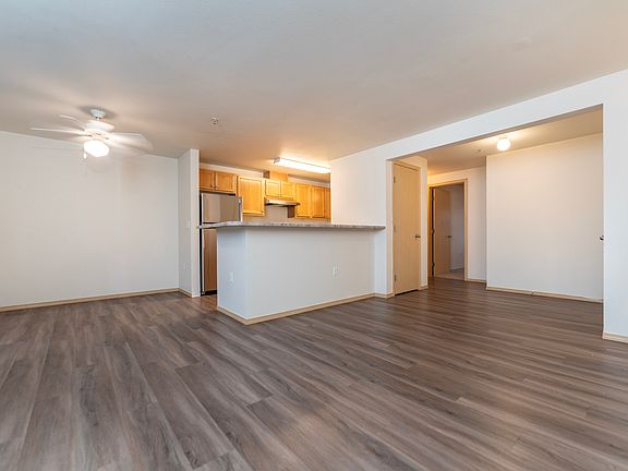 Spacious open-concept layout with a modern kitchen and wood-style flooring.