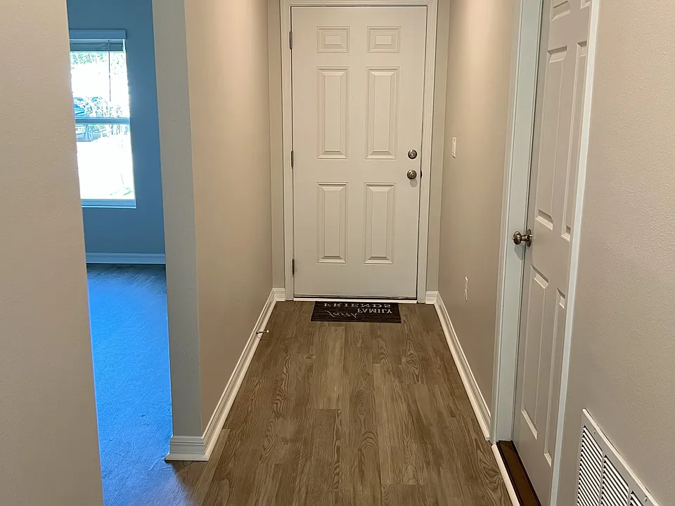 Entry and hallway. Garage door is on the right and front bedroom/bath are on the left.