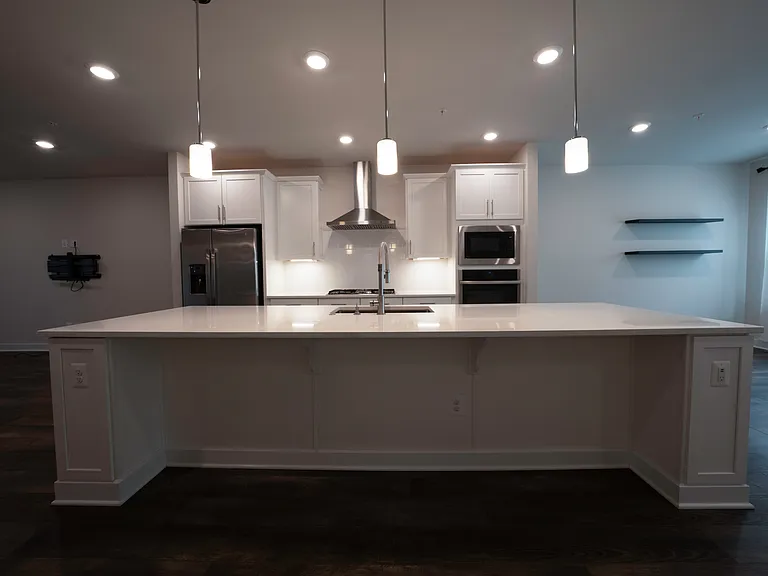 Large kitchen island comfortably fits four standard sized stool chairs and has built-in electrical outlets