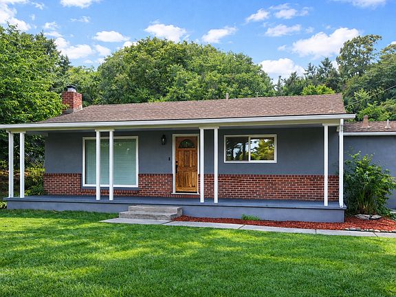 Single-level living enhanced by an expansive porch, mature trees, and bright natural light that highlights the home's balanced proportions.