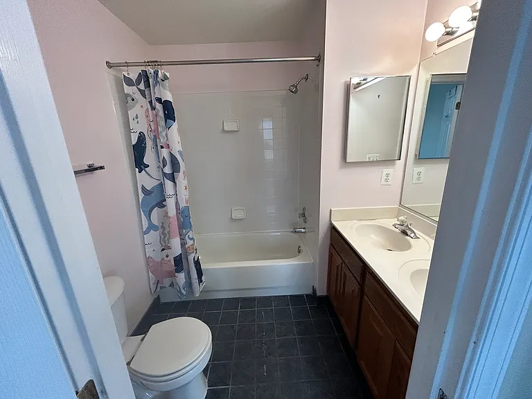 Back-facing bedroom on second floor with two vanities, tub, shower