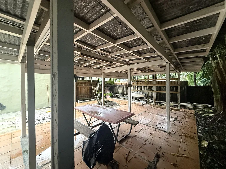 Second view of the cottage's dedicated backyard and covered patio, showing the size of the outdoor area and surrounding landscaping.