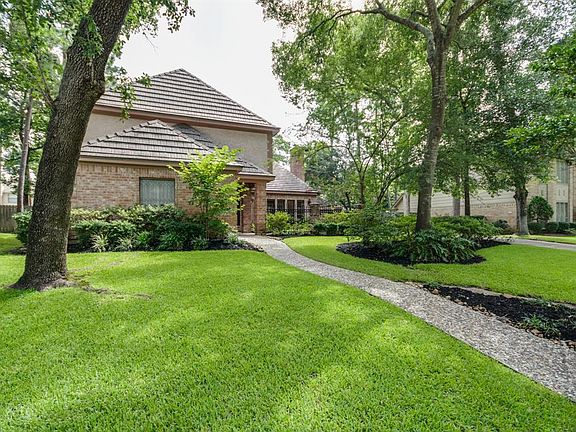 Lush green front yard with mature shade trees
