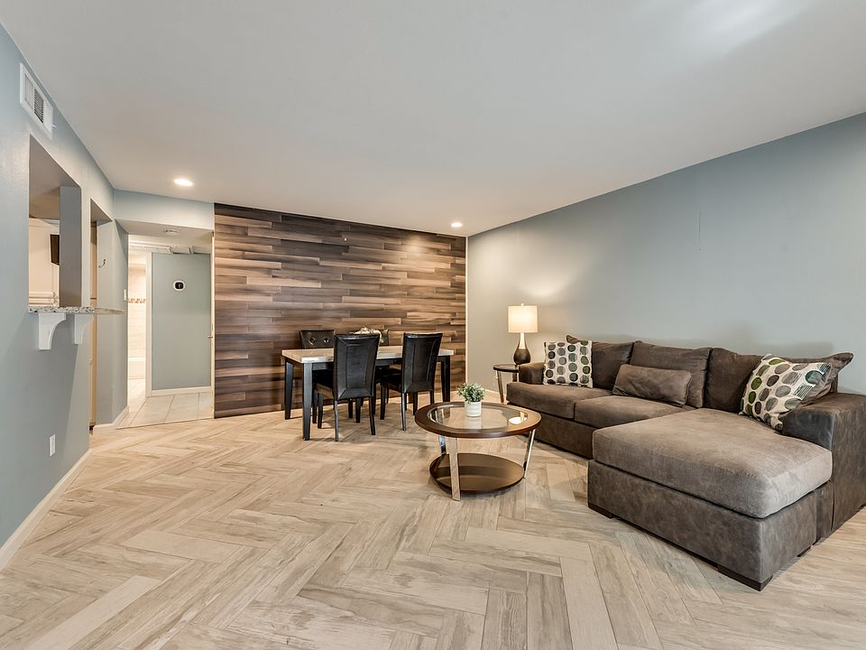 Dining and Living Room with light chevron pattern tile flooring, decorative wood wall.
