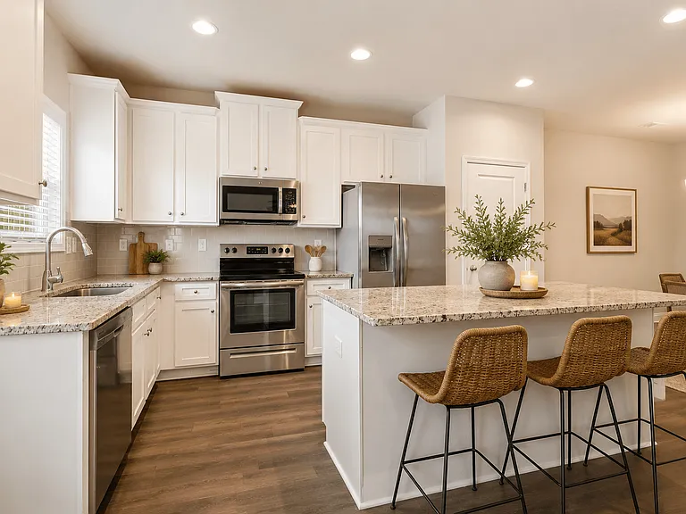 Spacious kitchen with an island, ample storage, stainless steel appliances and view into the living room.