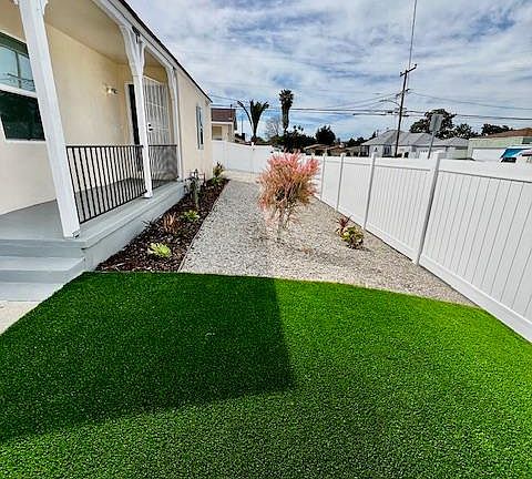 Brand New Artificial Turf in the front with Draught Resistant Plants.
