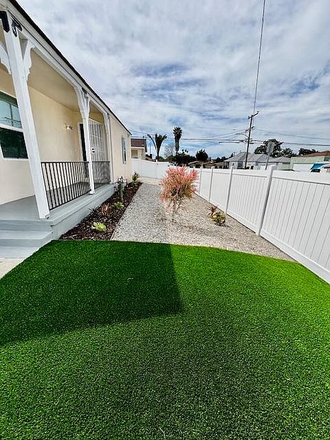 Brand New Artificial Turf in the front with Draught Resistant Plants.