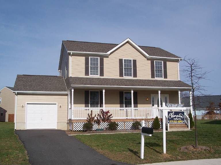 Front of home, covered front porch, landscaped yard, paved drive