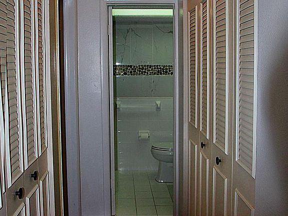 Hallway to the bathroom and bedroom with closets