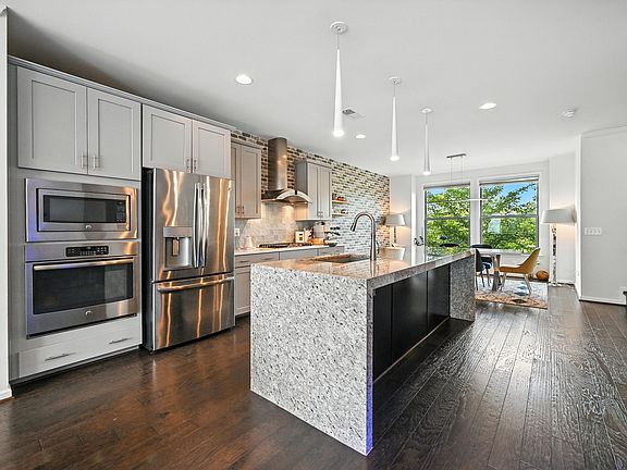 At the heart of the home sits a gourmet chef's kitchen, anchored by a stunning waterfall mitered island. This architectural centerpiece is designed for seamless entertaining and effortless social gatherings.