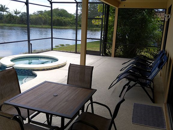 A view from the second bathroom to the partially covered lanai providing our guests with shade and shelter from the heat and sun while they absorb the sights and sounds of subtropical wilderness. A dining set for 4 and four zero gravity chairs are shown.