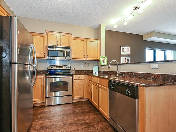 Open Kitchen with granite counters, stainless steel appliances, maple cabinets.