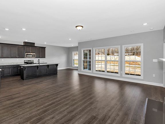 The open concept Claremont plan is filled with natural light and showcases an electric fireplace. En