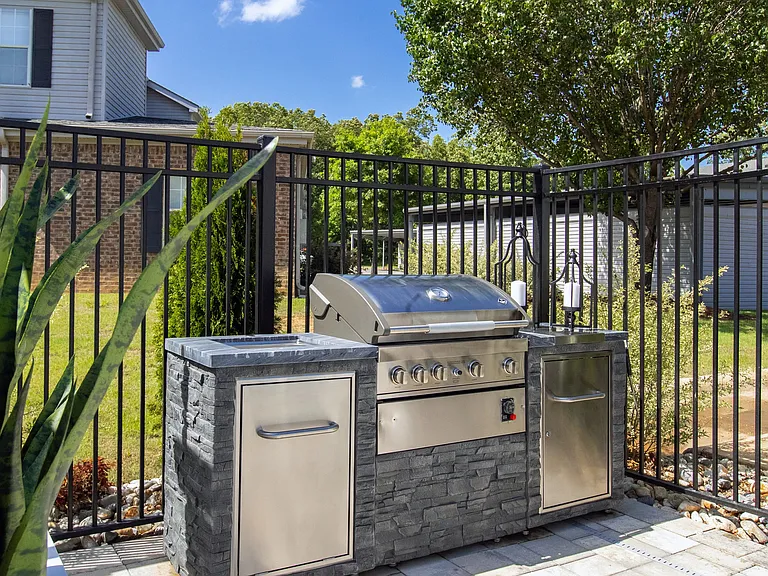 Savor the joy of at-home cookouts with our outdoor kitchen featuring a convenient gas grill with extra counterspace for memorable poolside barbecue experiences.