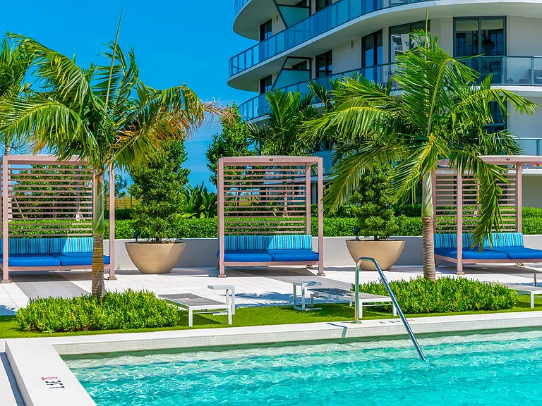 Poolside cabanas provide a shaded retreat for relaxation and waterfront living.