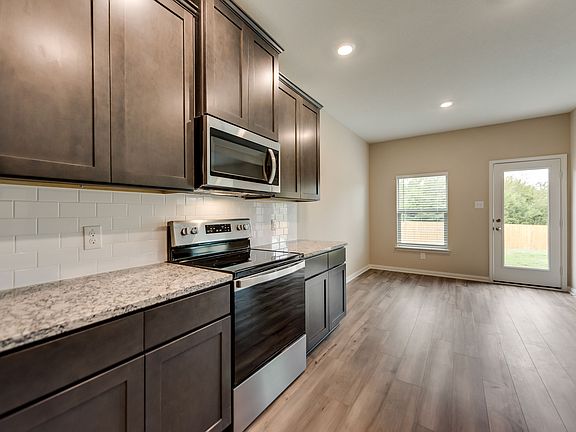 The kitchen showcases a full suite of stainless steel appliances.