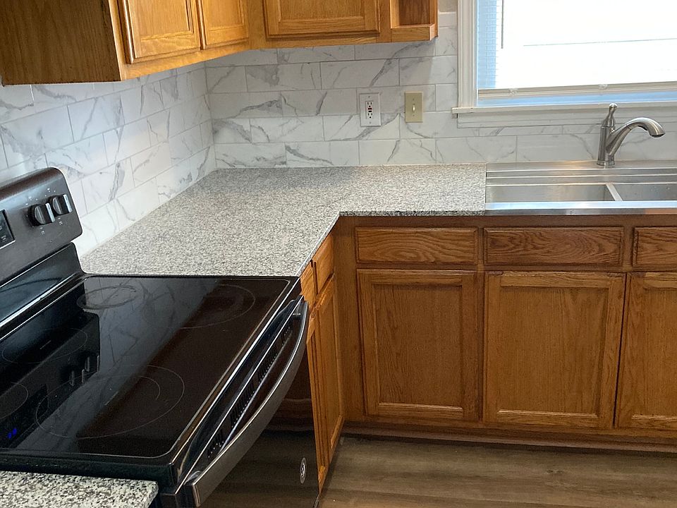 granite counter tops, flat top stove and deep sink in kitchen
