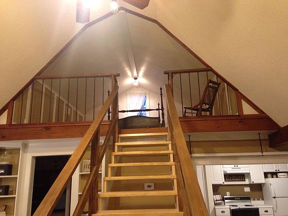Loft bedroom has wide plank hardwood floors.