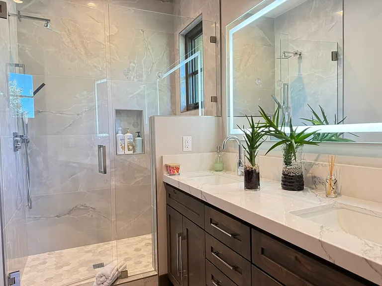 Spacious en-suite bathroom with large walk in shower and double sink vanity.