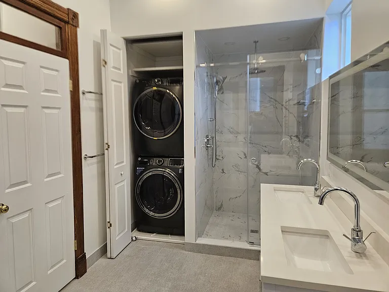 2nd floor: bathroom with washer dryer, shower and double sink vanity