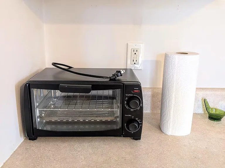 Kitchen counter space with upper cabinets and convenient outlets, ideal for small appliances and everyday meal prep.