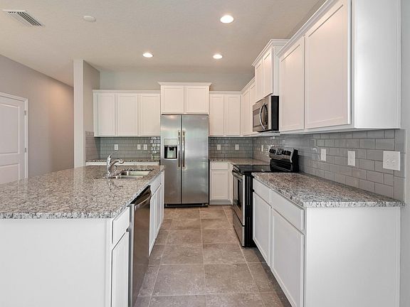 Beautiful modern kitchen with gray subway tile backsplash and all new stainless steel appliances