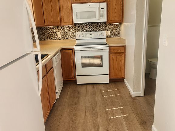 Kitchen includes refrigerator, stove, built in microwave, dishwasher, and garbage disposal.