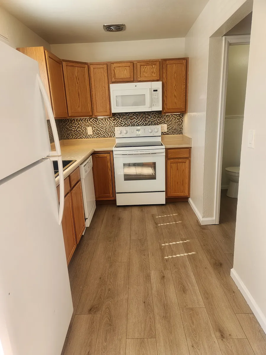Kitchen includes refrigerator, stove, built in microwave, dishwasher, and garbage disposal. - 5494 S Huron St #D