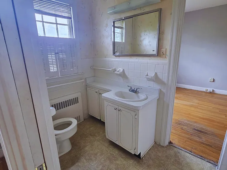 Comfortable bathroom with vanity, mirror, and towel rack.
