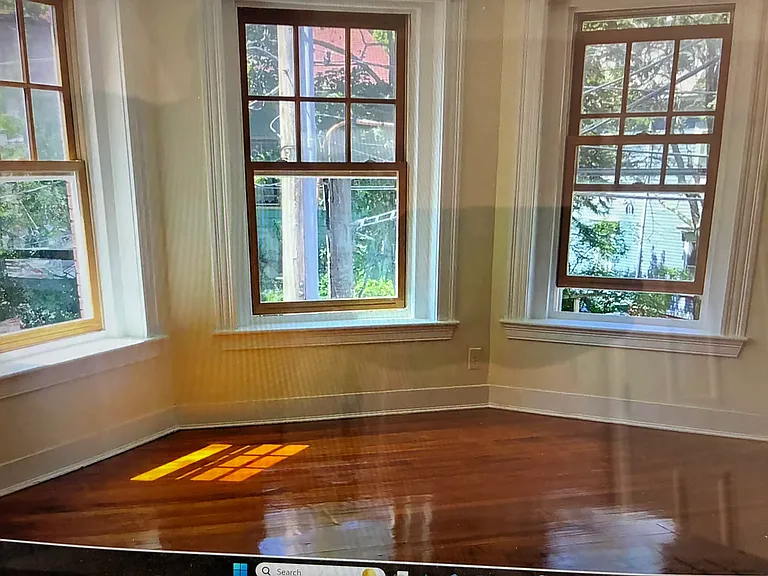 The large living room of this corner unit has expansive windows and beautiful finished hardwood flooring.