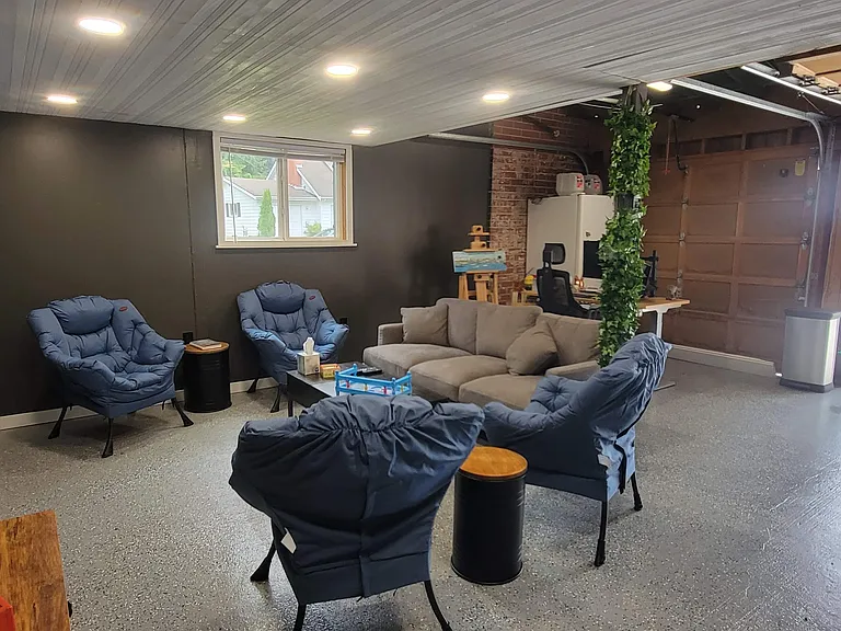 Garage. Was used as seating area with 43 inch mounted TV. Furniture, desk and screen available in furnished option