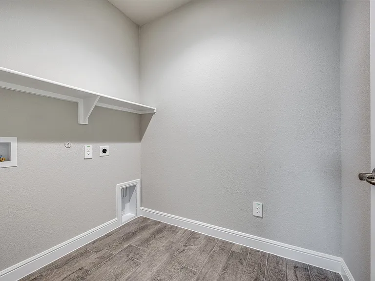 Clothes washing area with hookup for a gas dryer, washer hookup, electric dryer hookup, and hardwood / wood-style floors