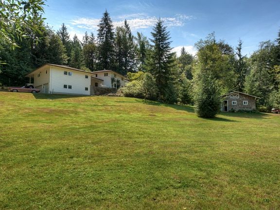 A view of the home from the pasture; could be a great home for horses. The custom shed is large enough to hold a riding mower, tractor, and other yard equipment - or additional cars.
