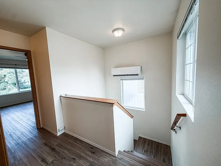 Top of stairs. Master bed room at top of stairs and 2 guest rooms and full bathroom to the left. A/C unit above window.