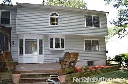 Back of 3 story house with yard and deck