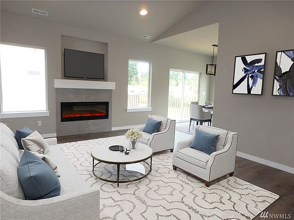 A fantastic living room with modern fireplace, vaulted ceilings, wiring for TV over fireplace, built-in speakers, and plenty of space & light